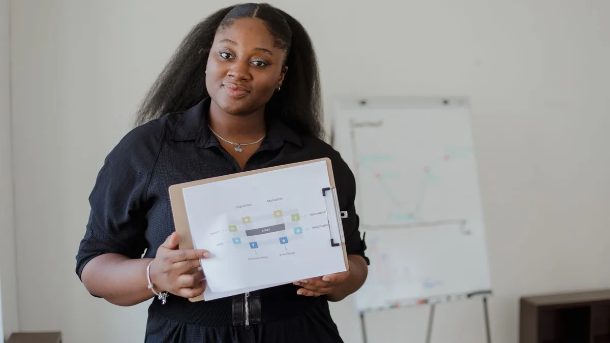 Confident woman giving a presentation with visual aids in a modern office environment.