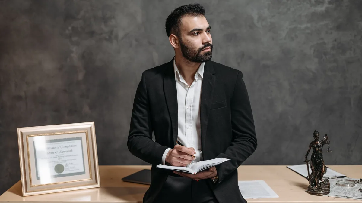 Confident male consultant takes notes, surrounded by legal paperwork in a modern office.